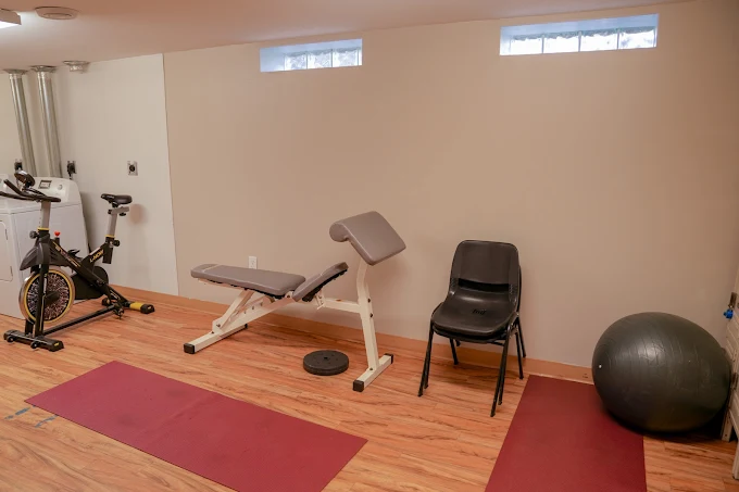 Exercise room with bench, bike, and yoga mats