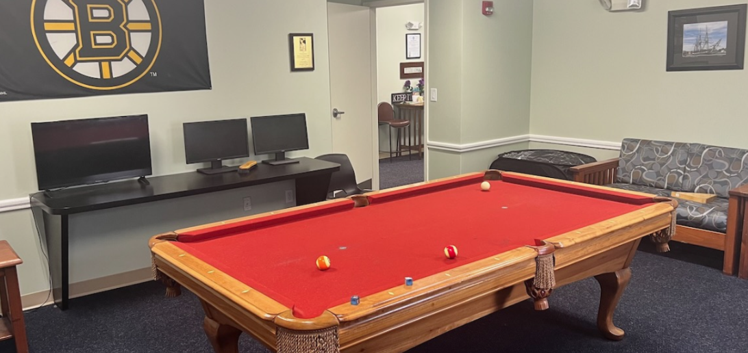 Recreation room featuring a red-felt pool table, computer stations, and seating