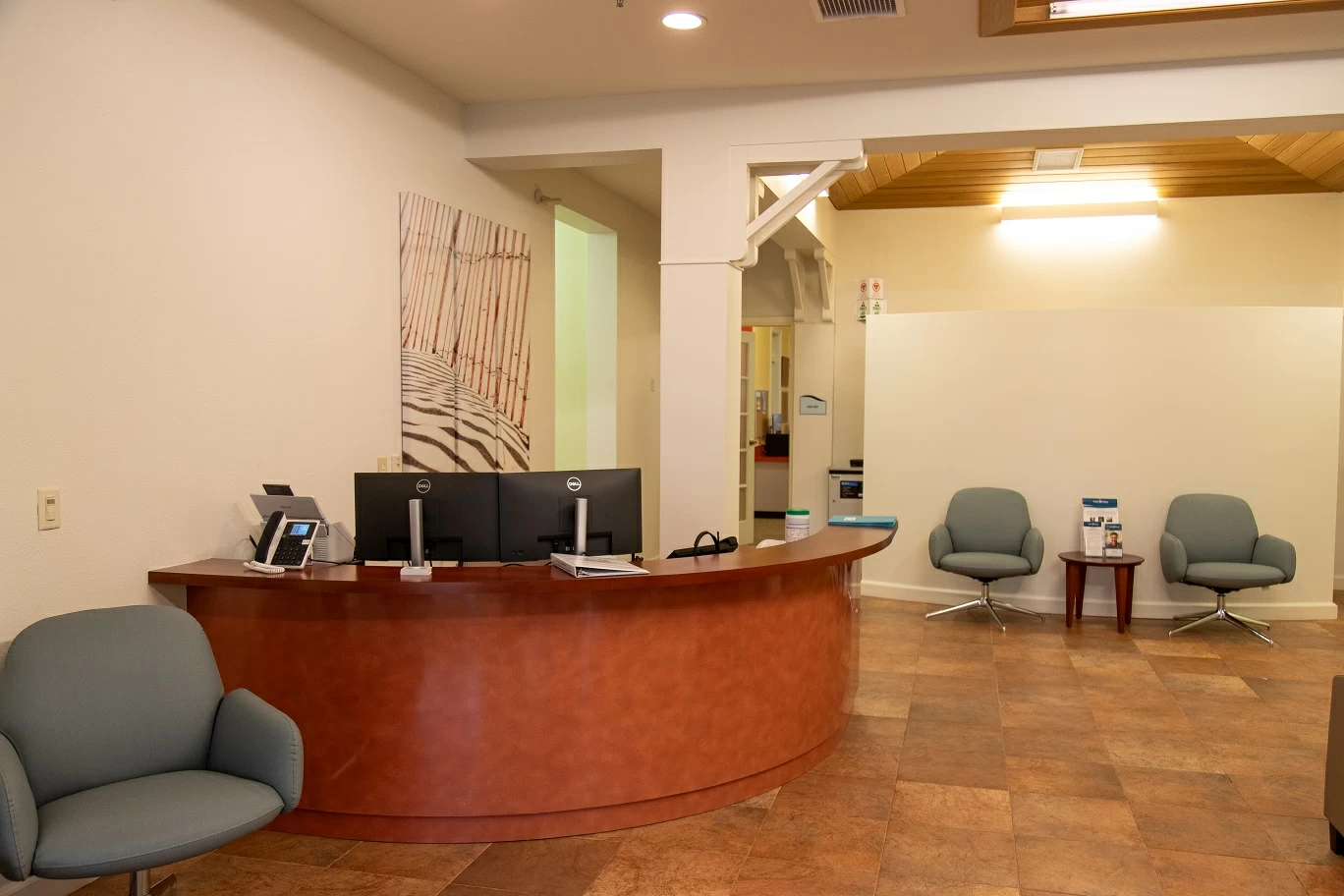 Curved wood reception desk with seating area and warm lighting inside recovery center lobby