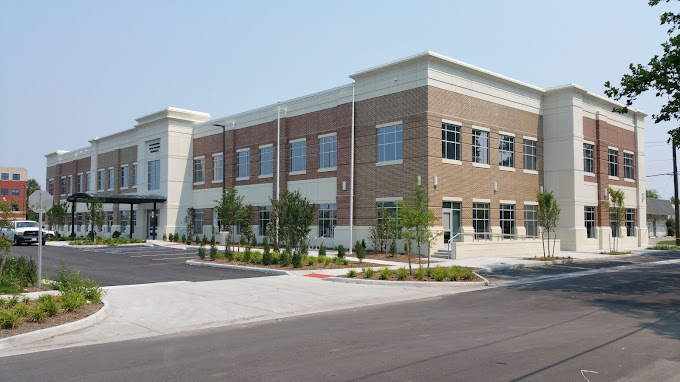 Street view of a contemporary outpatient facility with a spacious parking area.