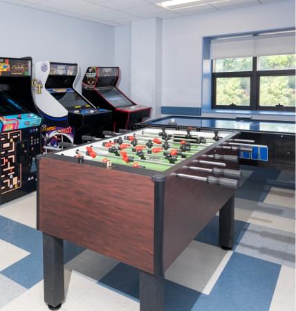 Arcade machines and foosball table in recreation room