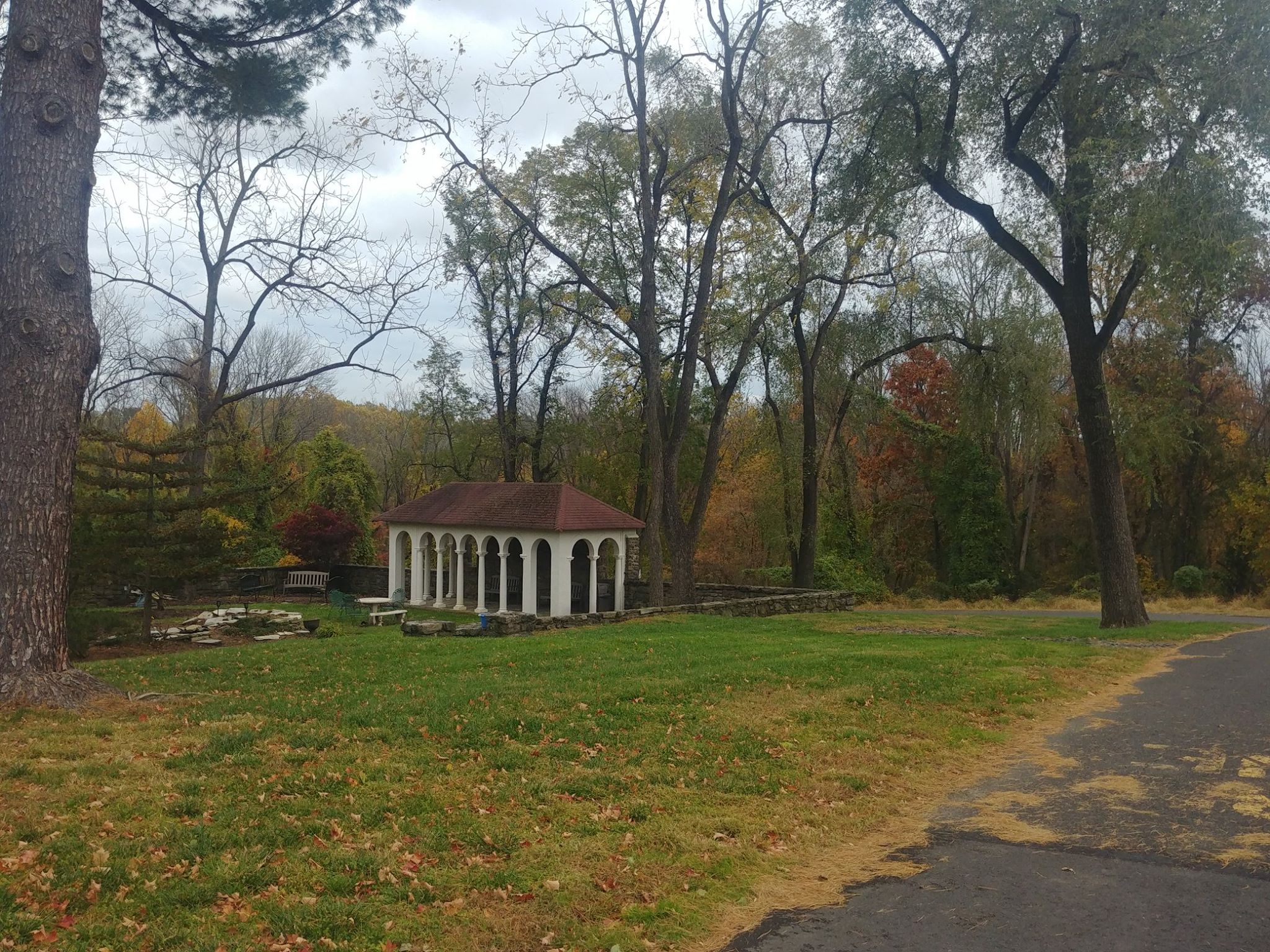 Small pavilion surrounded by trees on a quiet wooded lawn
