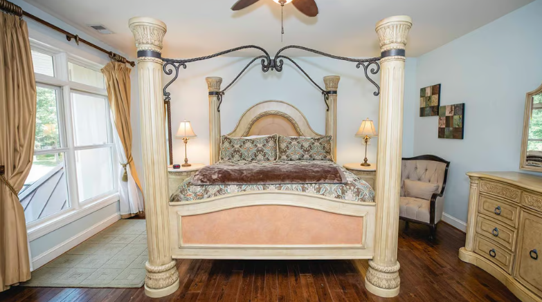 Luxurious bedroom with ornate four-poster bed and large windows