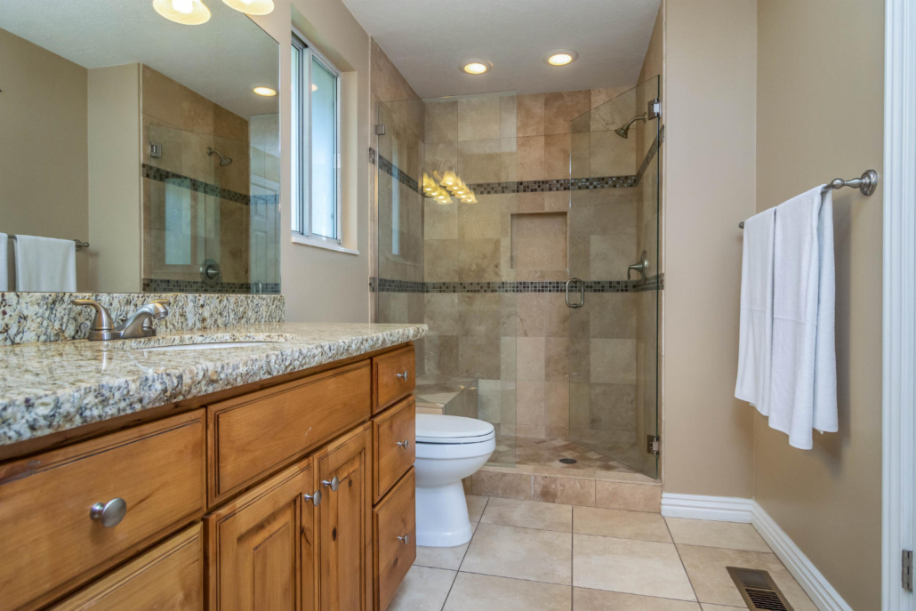 Bathroom with granite vanity and tiled shower