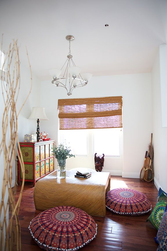 Bright meditation room with floor cushions and wood decor