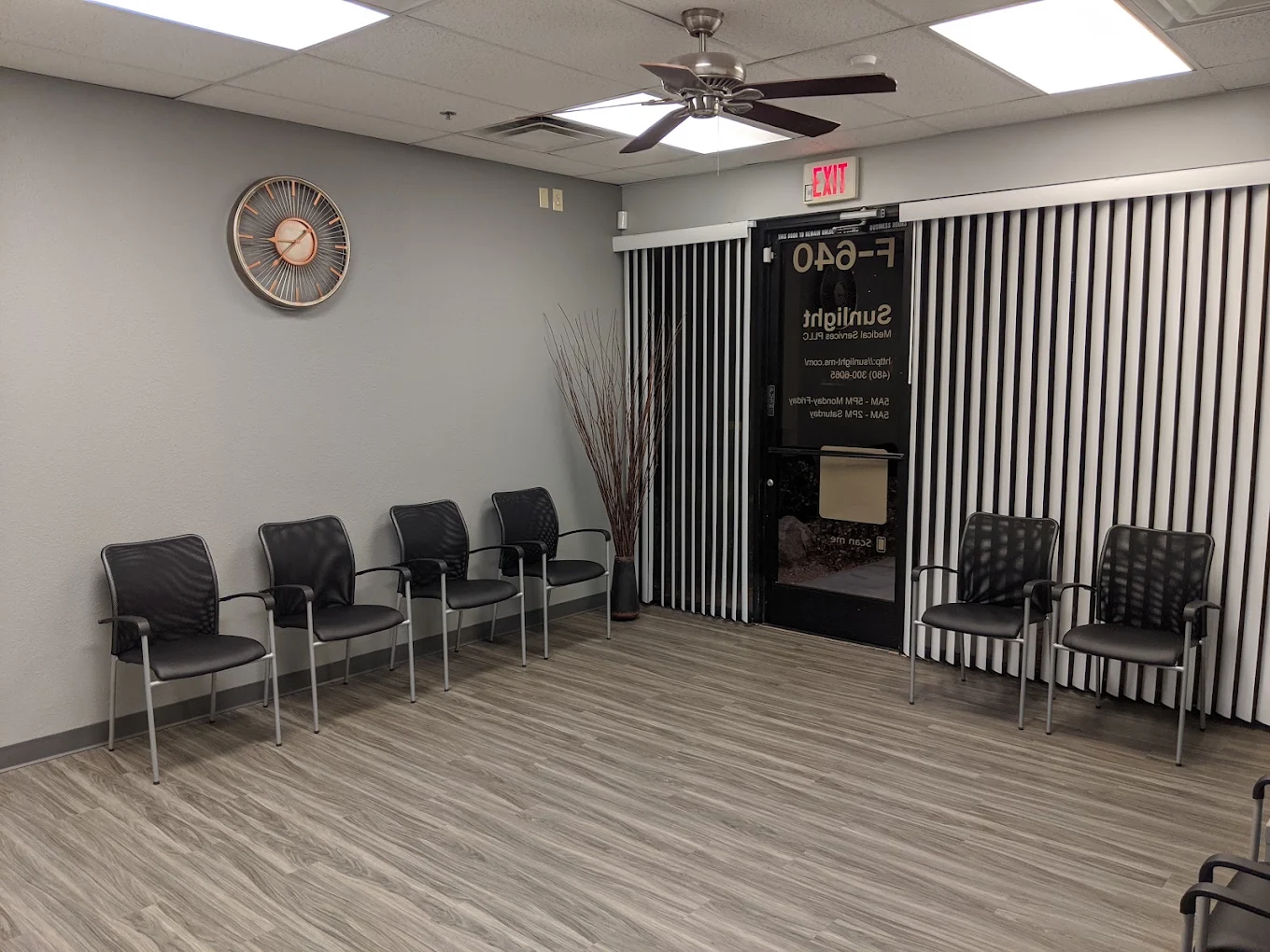 Waiting area with black chairs and vertical window blinds