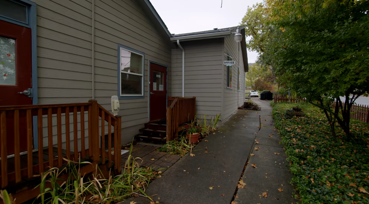 Building exterior with red doors and office sign