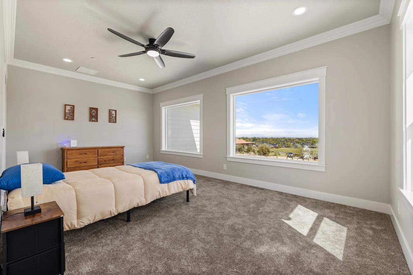Shared bedroom with two beds, dresser, and large windows