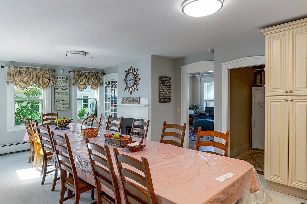 Long dining table with wooden chairs and wall decor