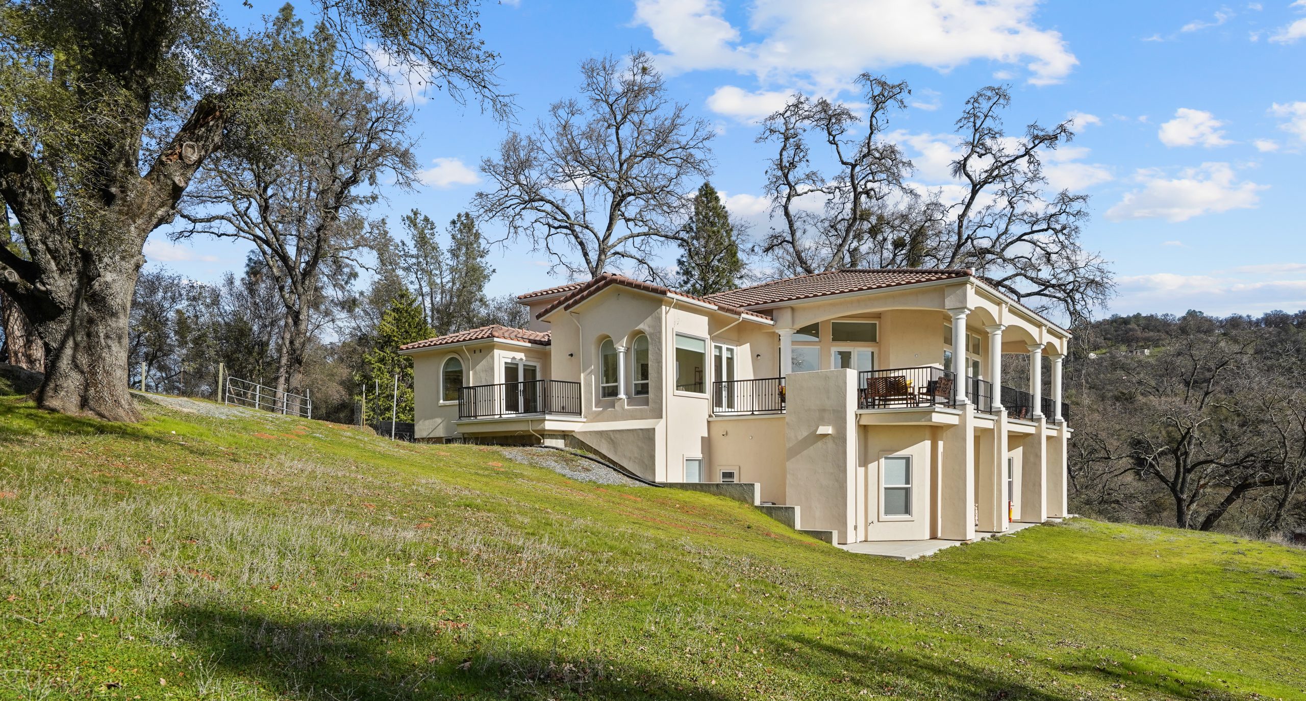 Large hillside residential facility surrounded by trees.