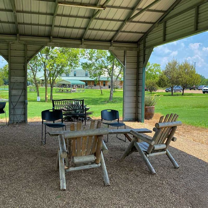 Covered outdoor seating area with wooden chairs