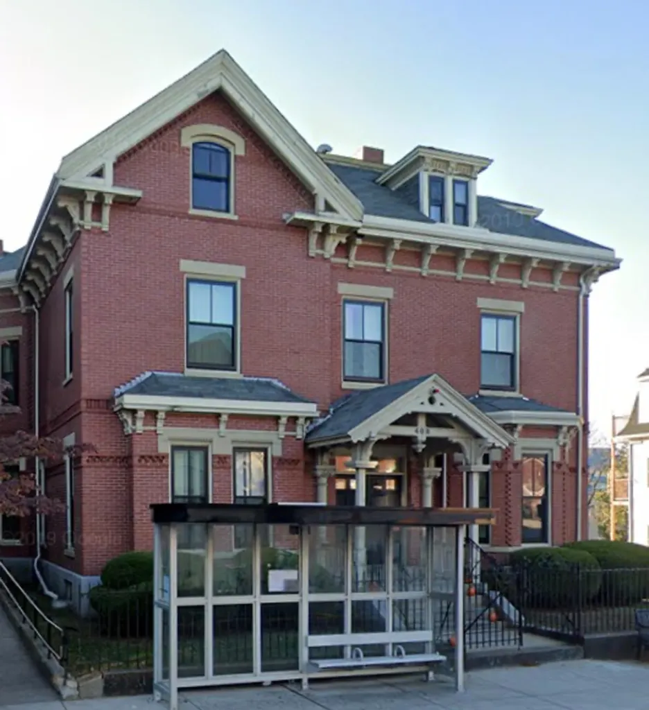 Brick rehab facility with front porch and bus stop in front