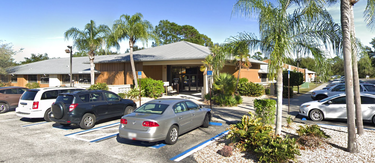 Front entrance with palm trees and parking lot