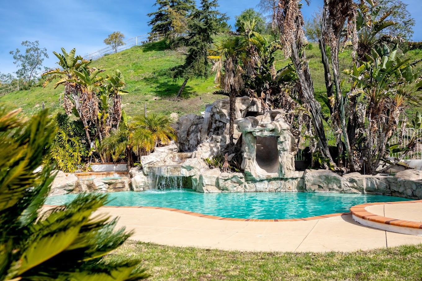 Pool with waterfall and tropical landscaping