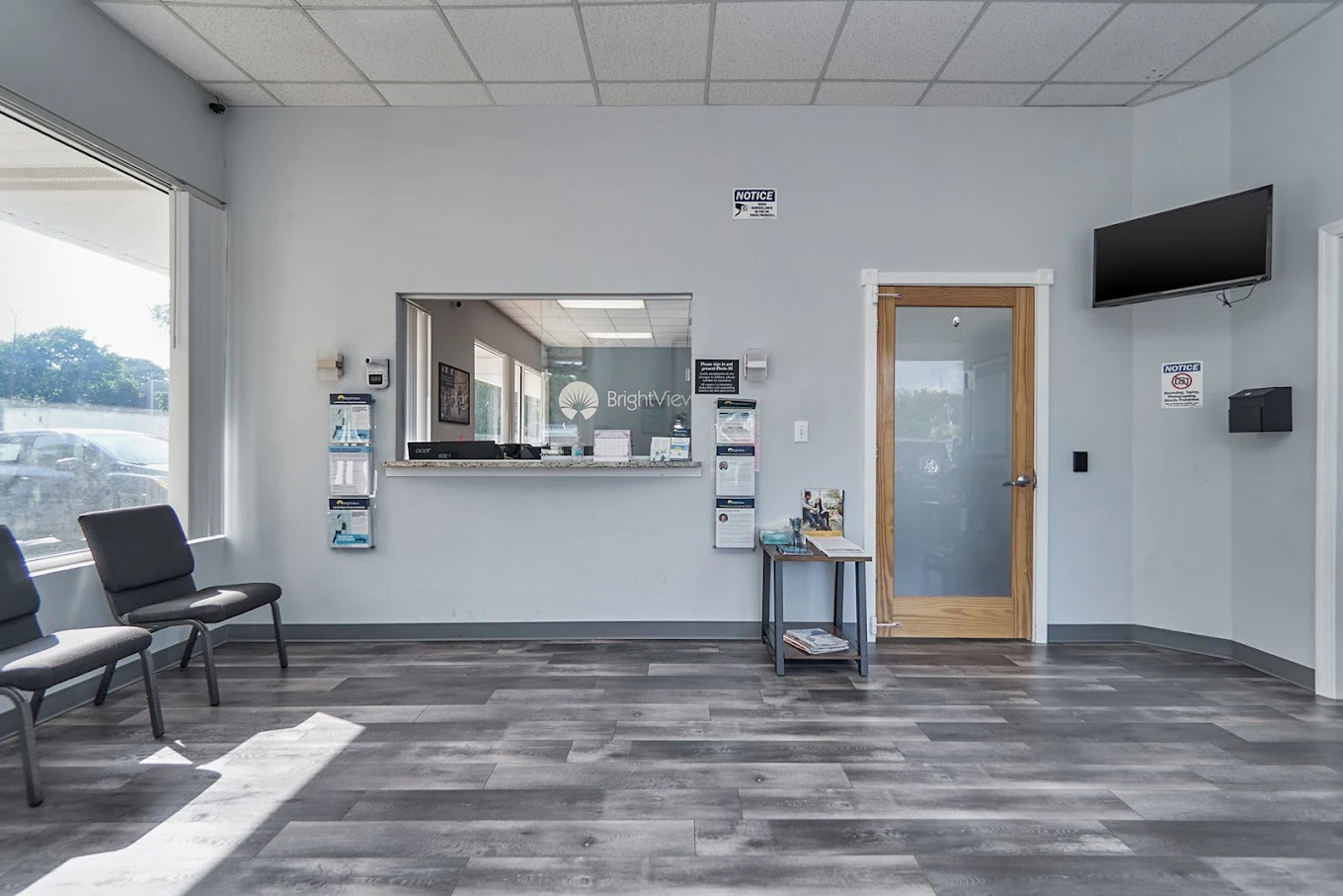 Check-in window with chairs, television, and brochure racks