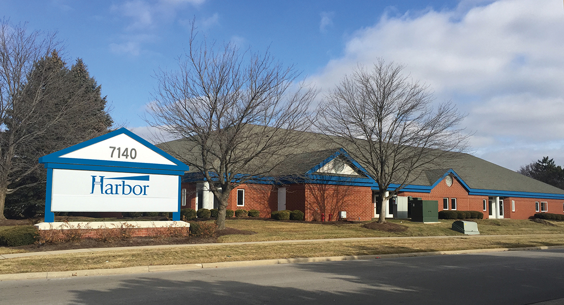 Brick building with blue trim and Harbor sign in front