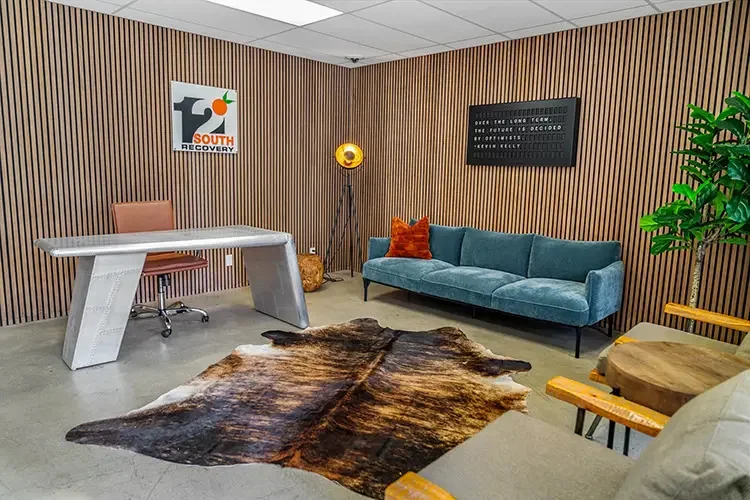 Stylish reception space with modern wood paneling, large sofa, and metal desk