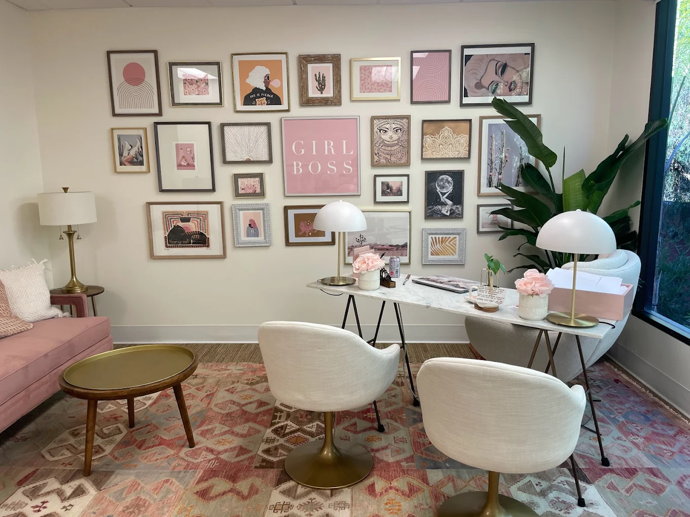 Stylish therapy office with pink décor and gallery wall