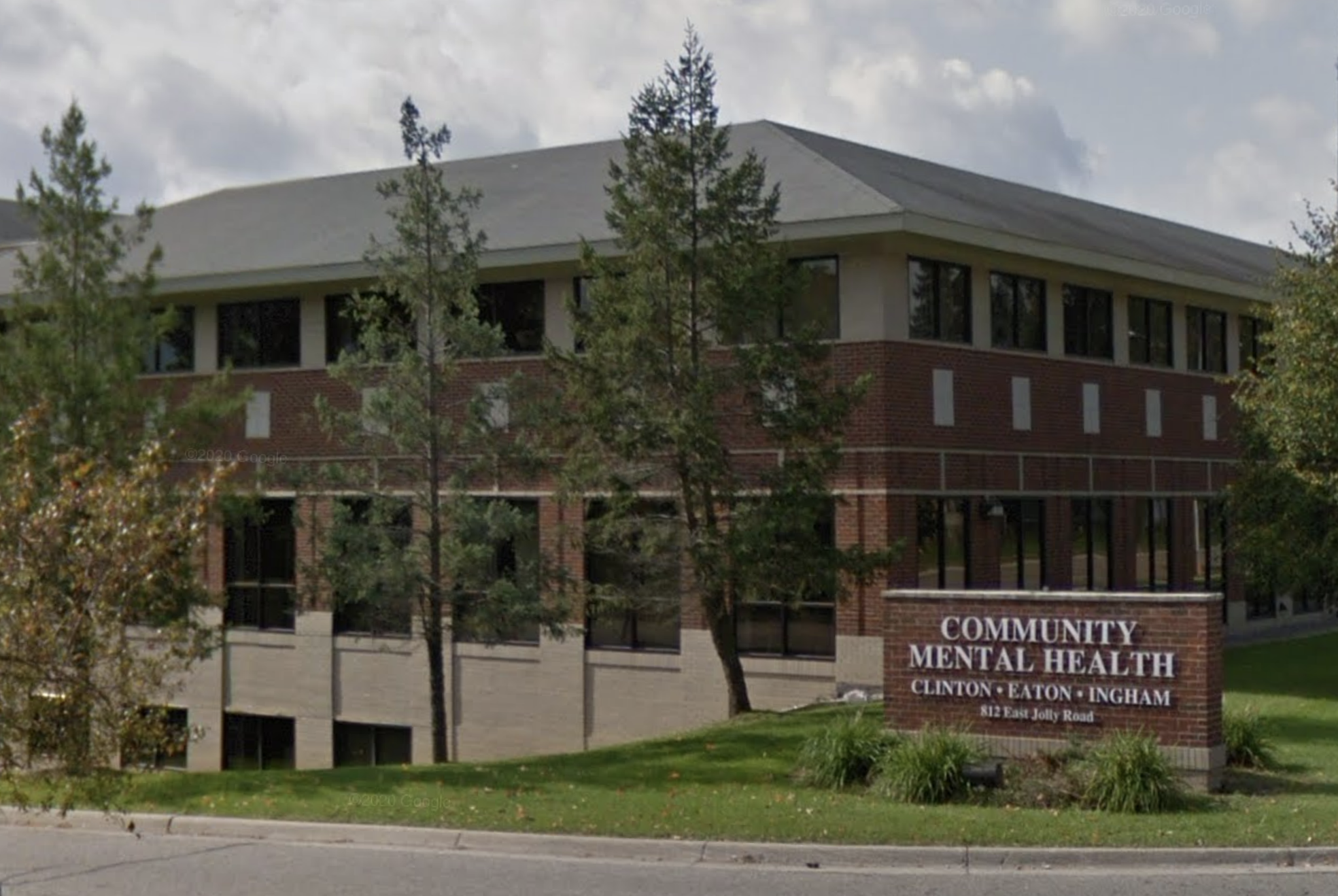 Multi-story brick building with large windows and entrance sign