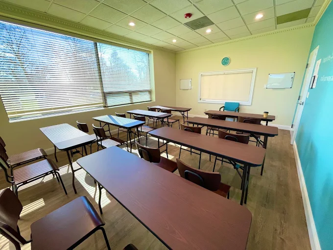 Bright therapy room with rows of tables and chairs