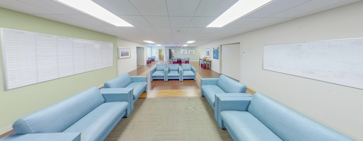 Group seating area with blue couches and whiteboards