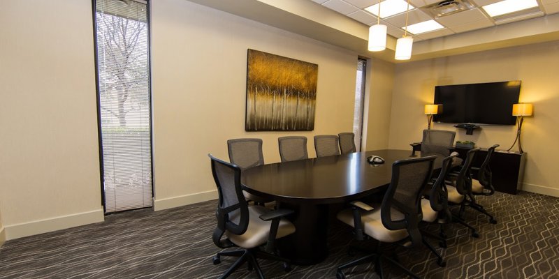 A well-lit conference room with a large table, comfortable chairs, and modern decor. The space is designed for productive meetings and discussions.