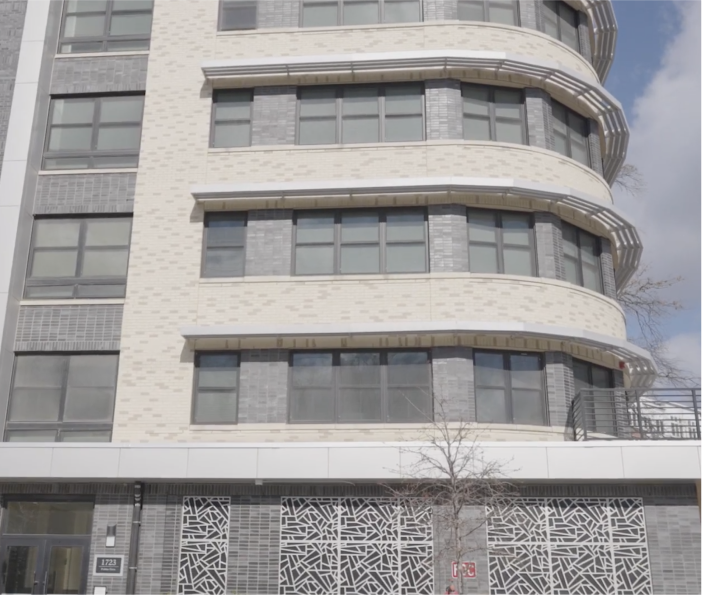 Modern multi-story building with large windows and patterned panels.