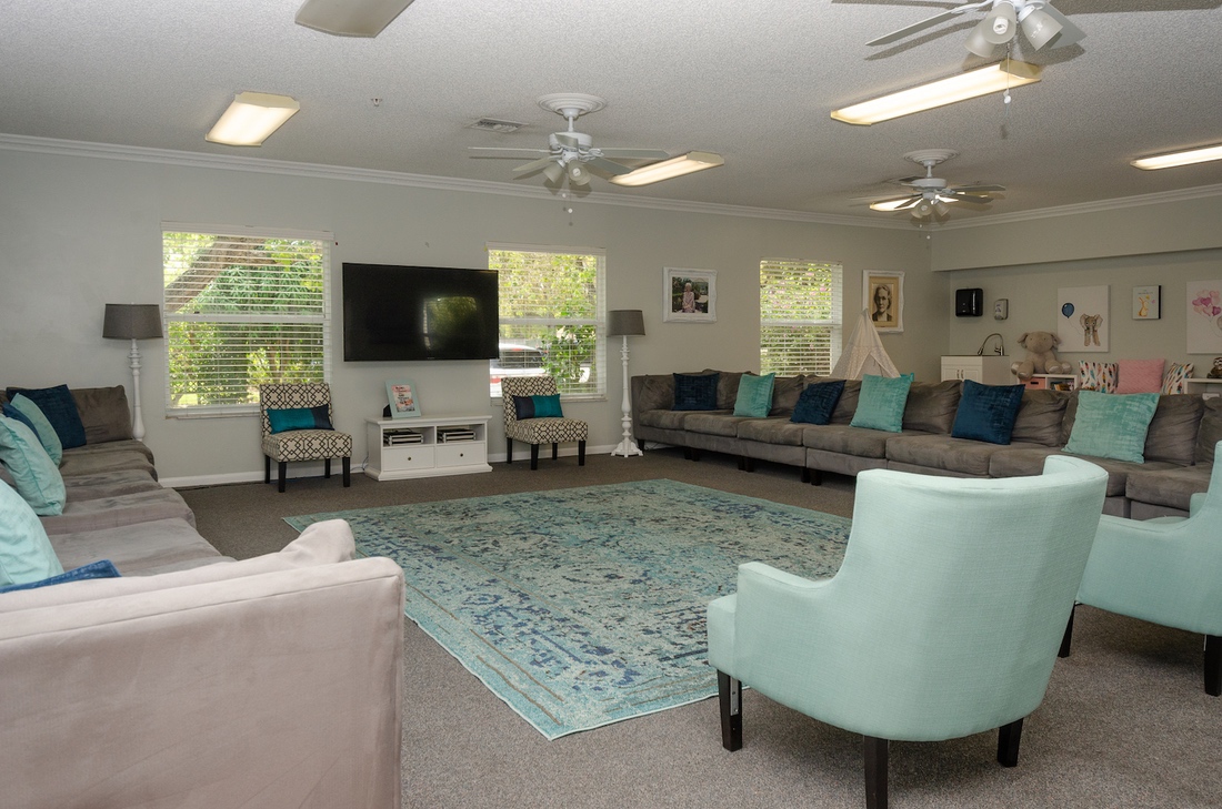 Spacious lounge with sofas, TV, and teal accents