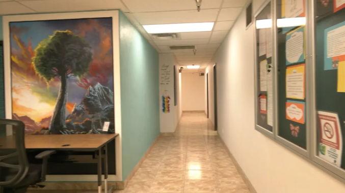 Bright hallway with wall art and a desk by the entrance