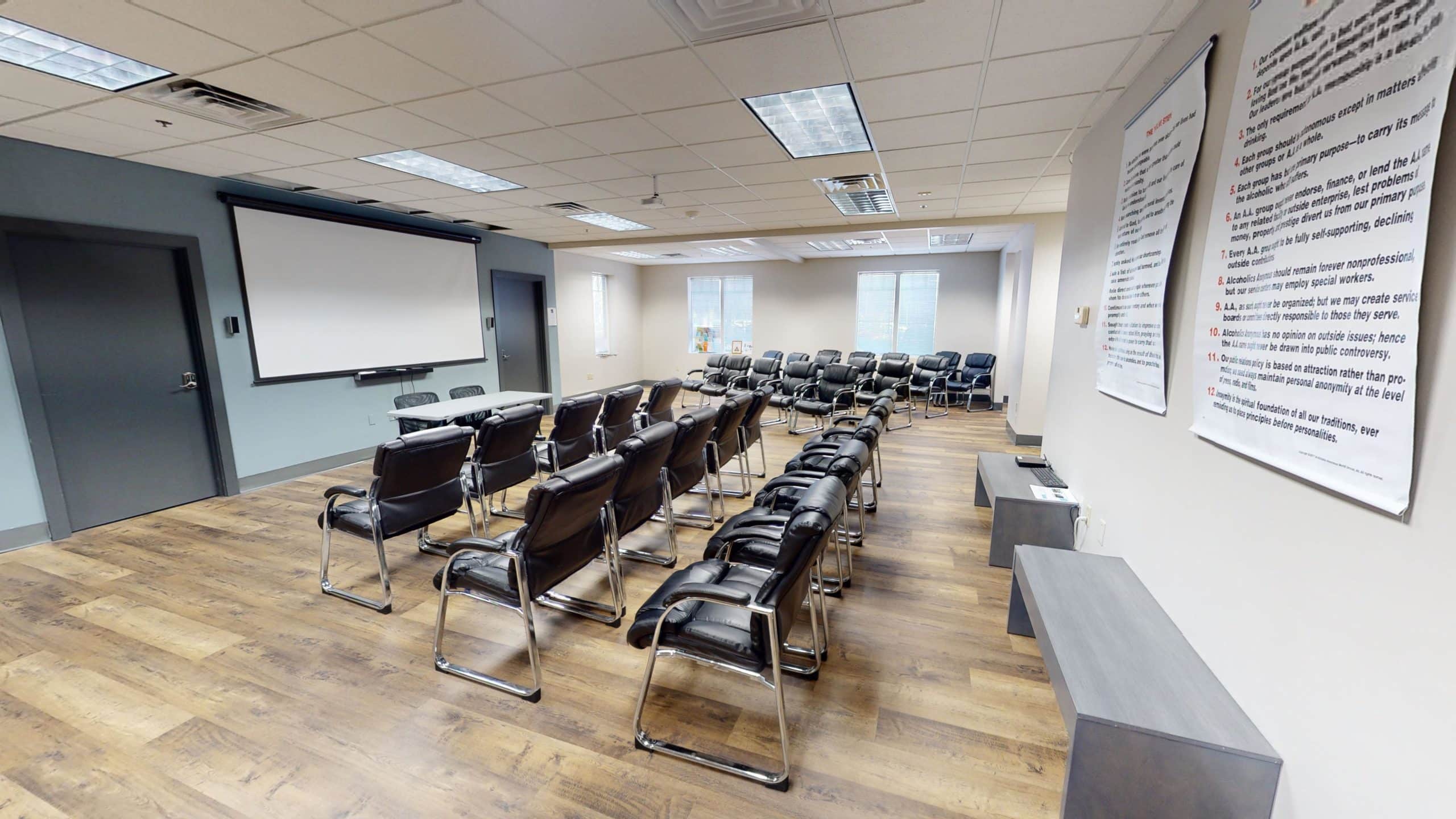 Meeting room with rows of chairs and projection screen