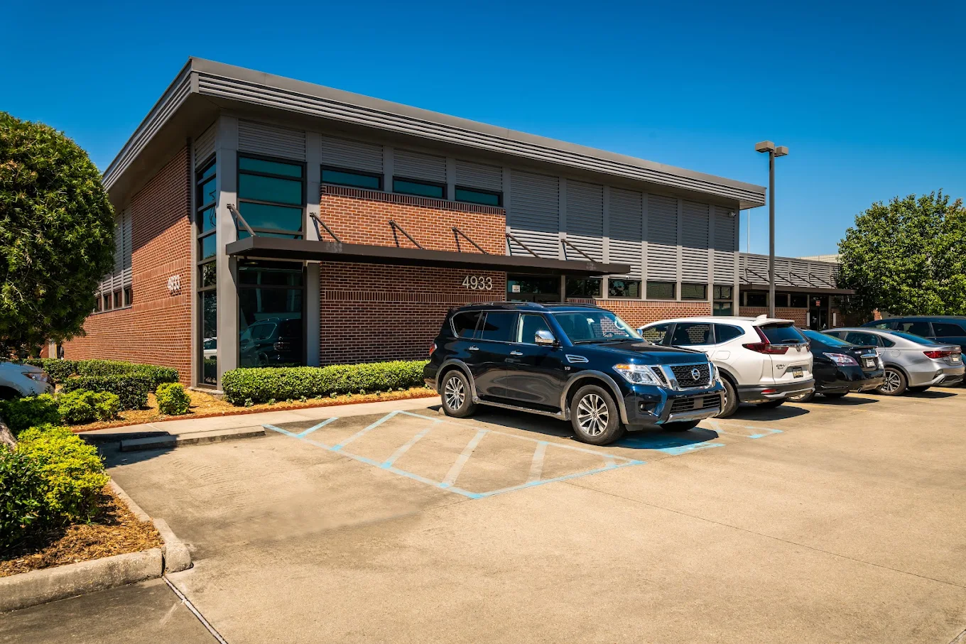 Exterior view of the brick Avenues Recovery Center facility in Metairie with parking spaces and landscaped grounds