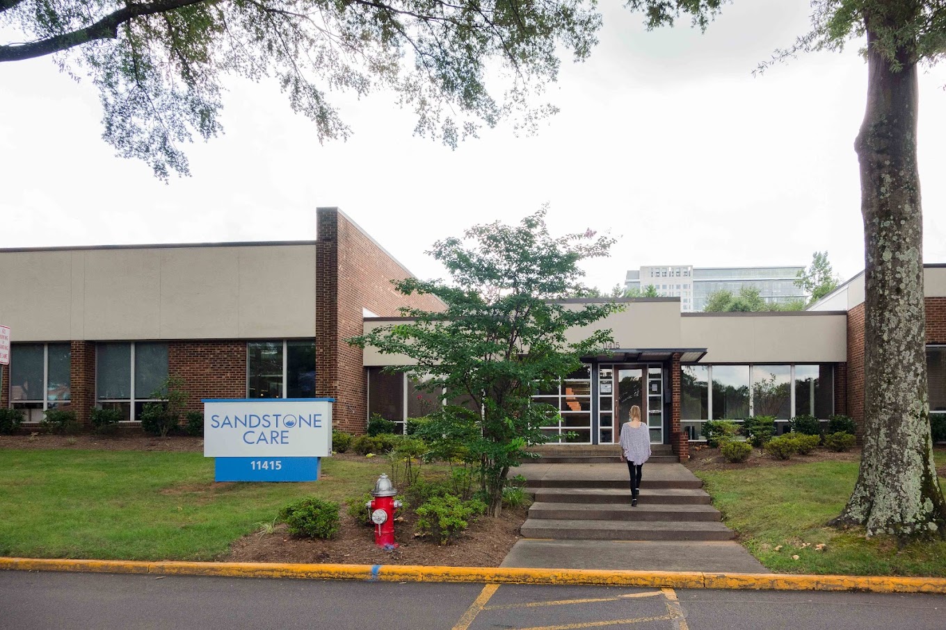 Facility exterior with glass facade and entry walkway.