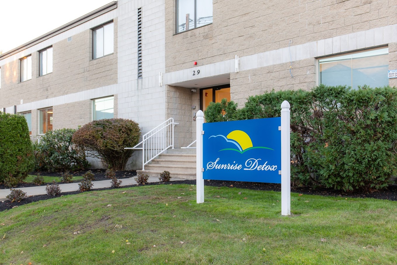 Entrance sign with green lawn and walkway leading to facility.