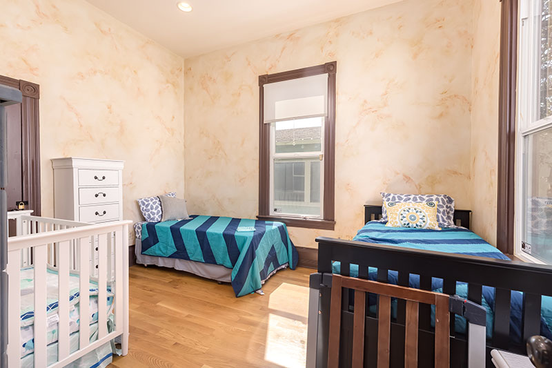 Bedroom with twin beds and crib for mothers with children