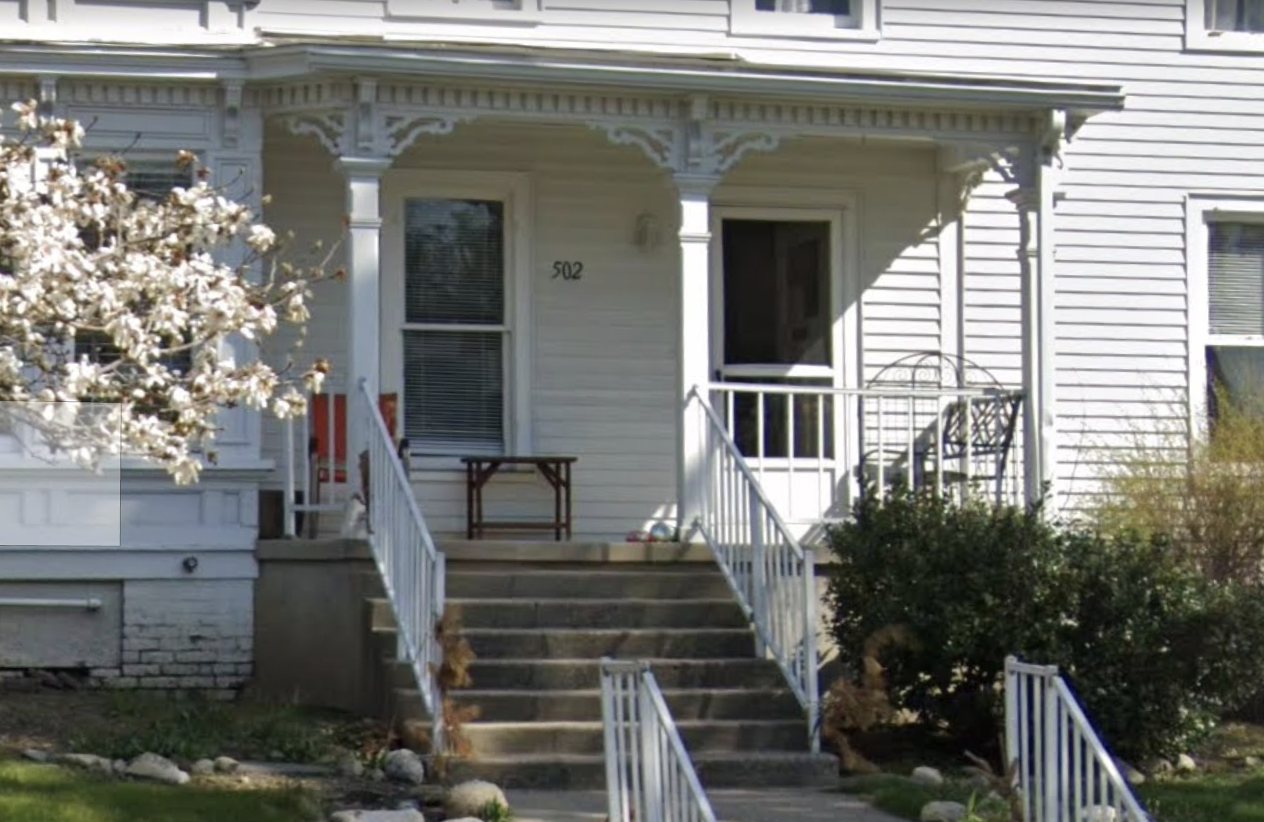 Covered front porch with steps and white railings