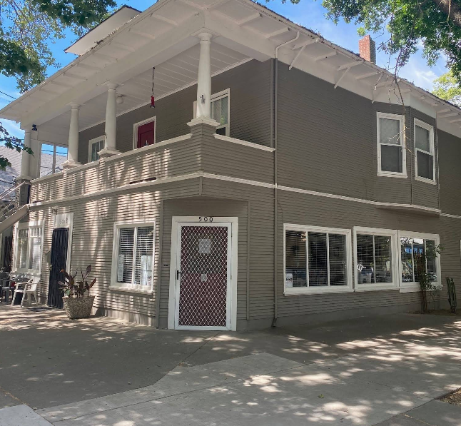 Two-story gray rehab center with porch and white trim