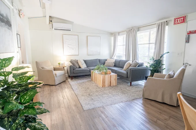 Cozy lounge with sofas, armchairs, and natural light