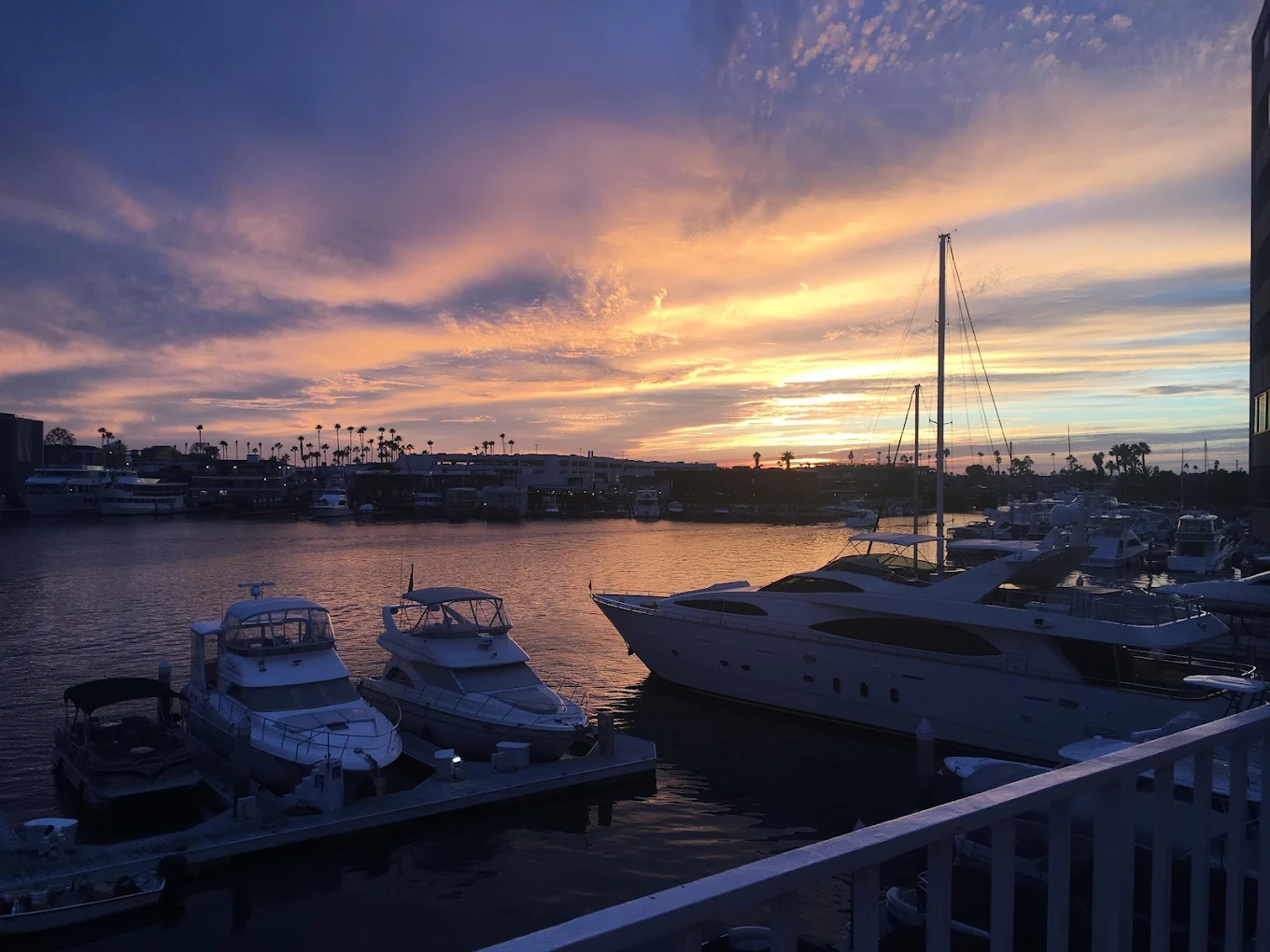 Boats on a marina at sunset with colorful sky