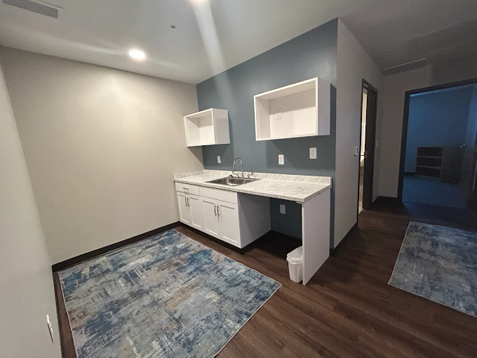 Kitchenette with sink and cabinets in client suite
