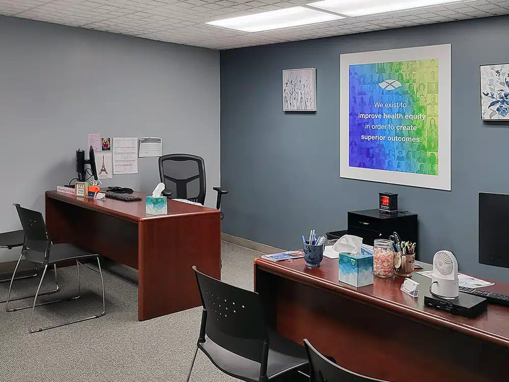 Office with desks, chairs, and health equity wall sign