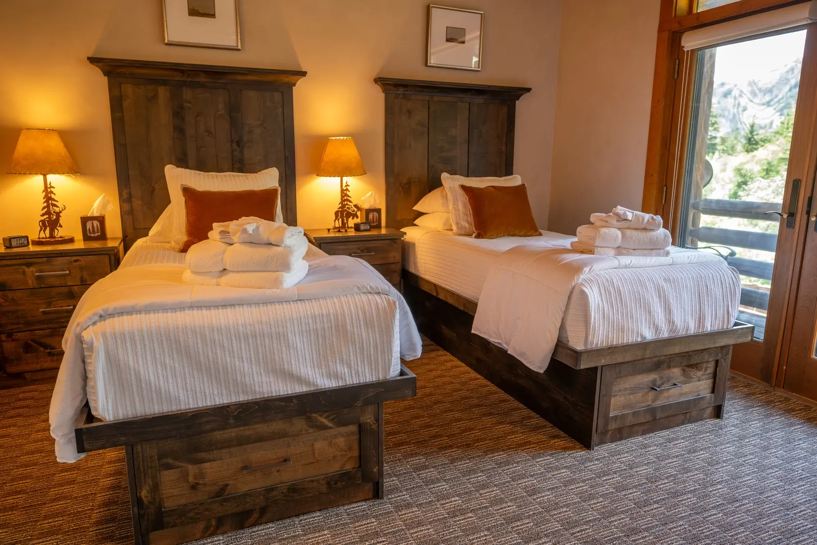 Twin beds with rustic headboards and a mountain view