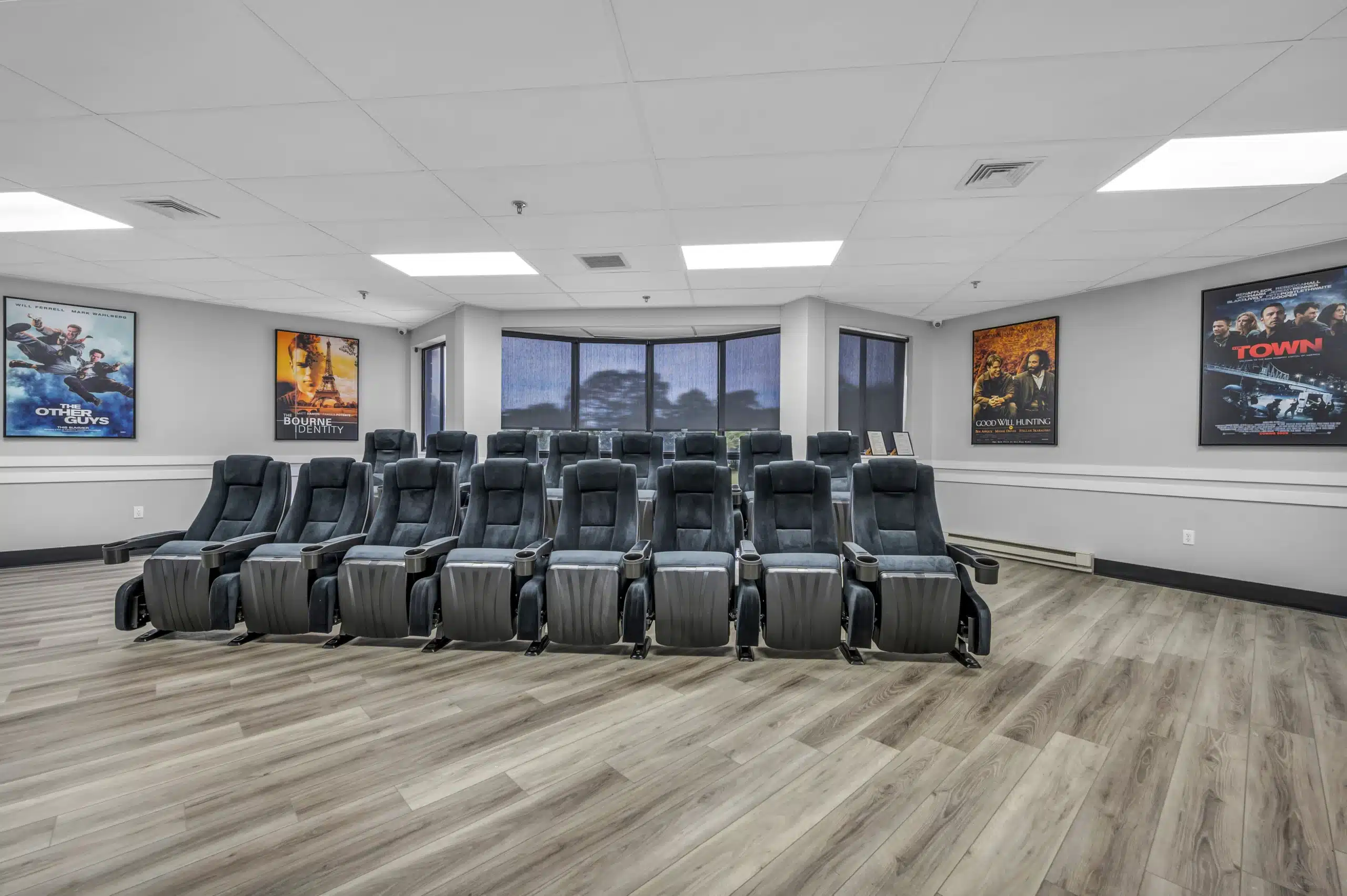 Screening room with recliner seating and movie posters on the walls at Boca Recovery Center Massachusetts
