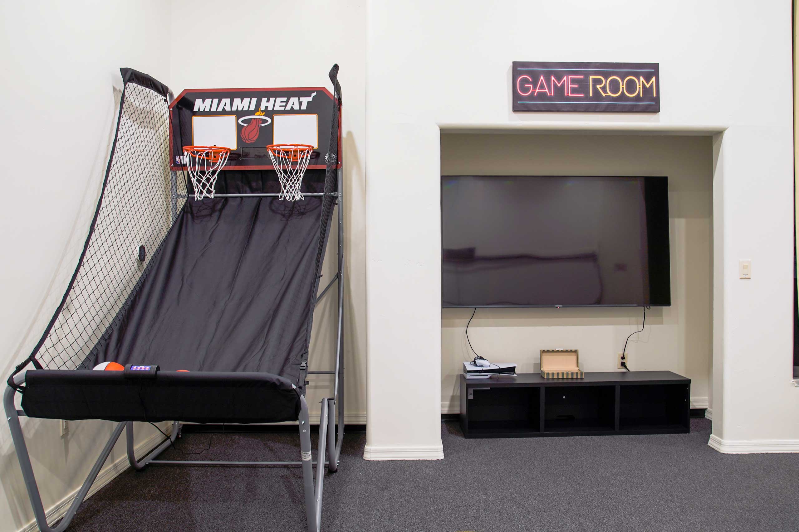 Indoor game room with basketball arcade and TV for teens