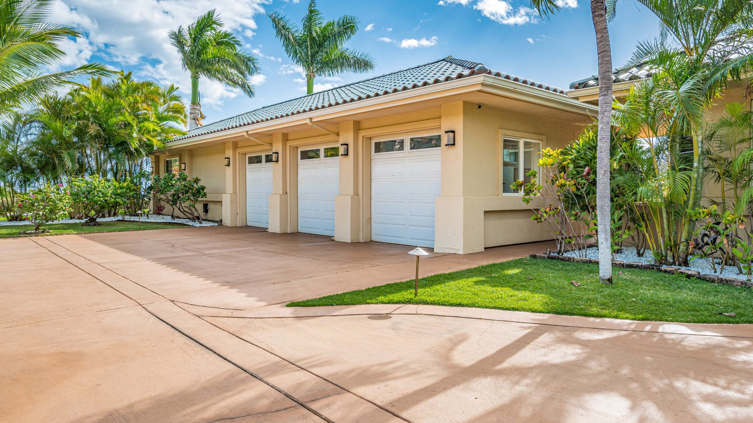 Palm-lined driveway leading to the estate's attached multi-car garage