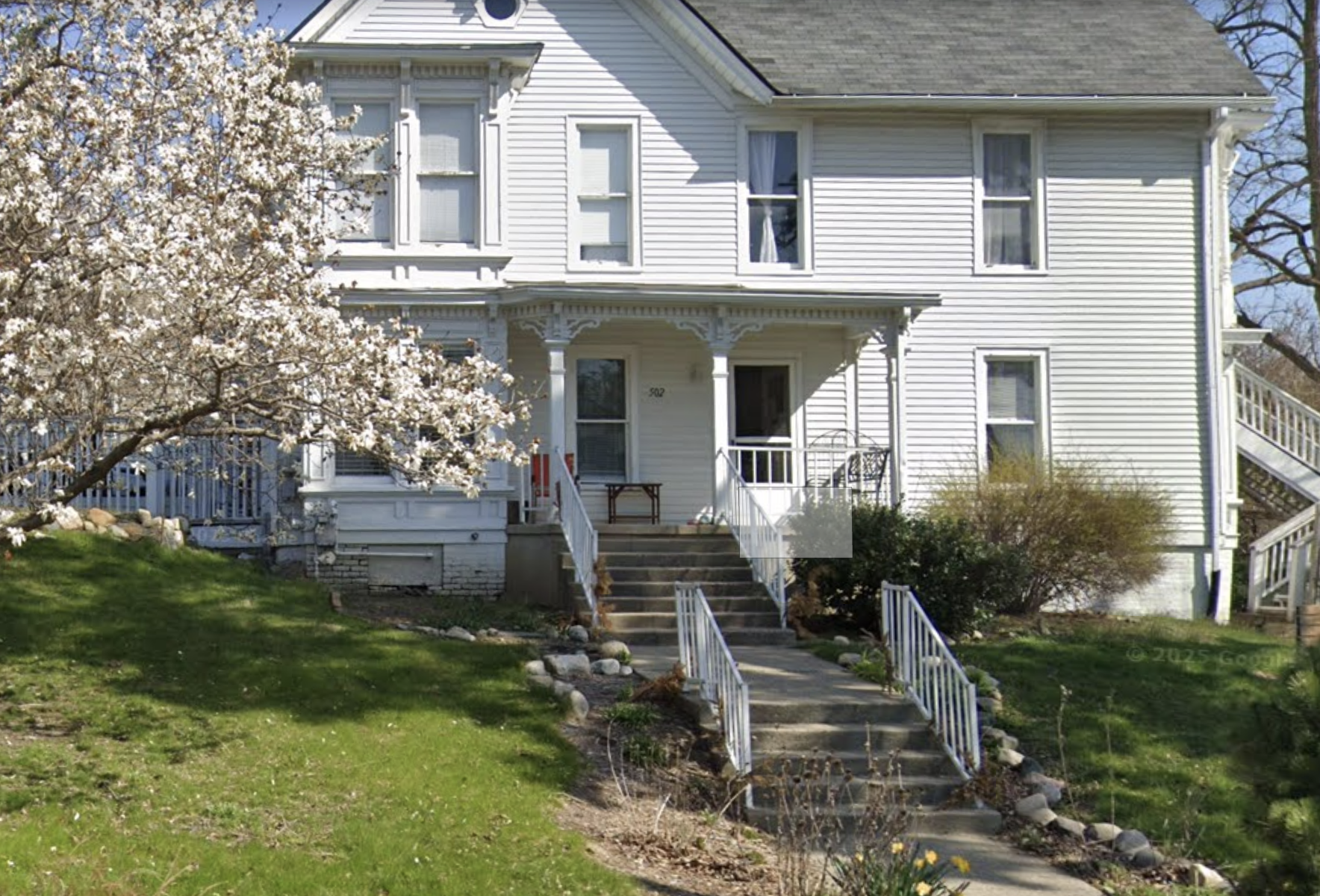 Front entrance of white residential facility with steps