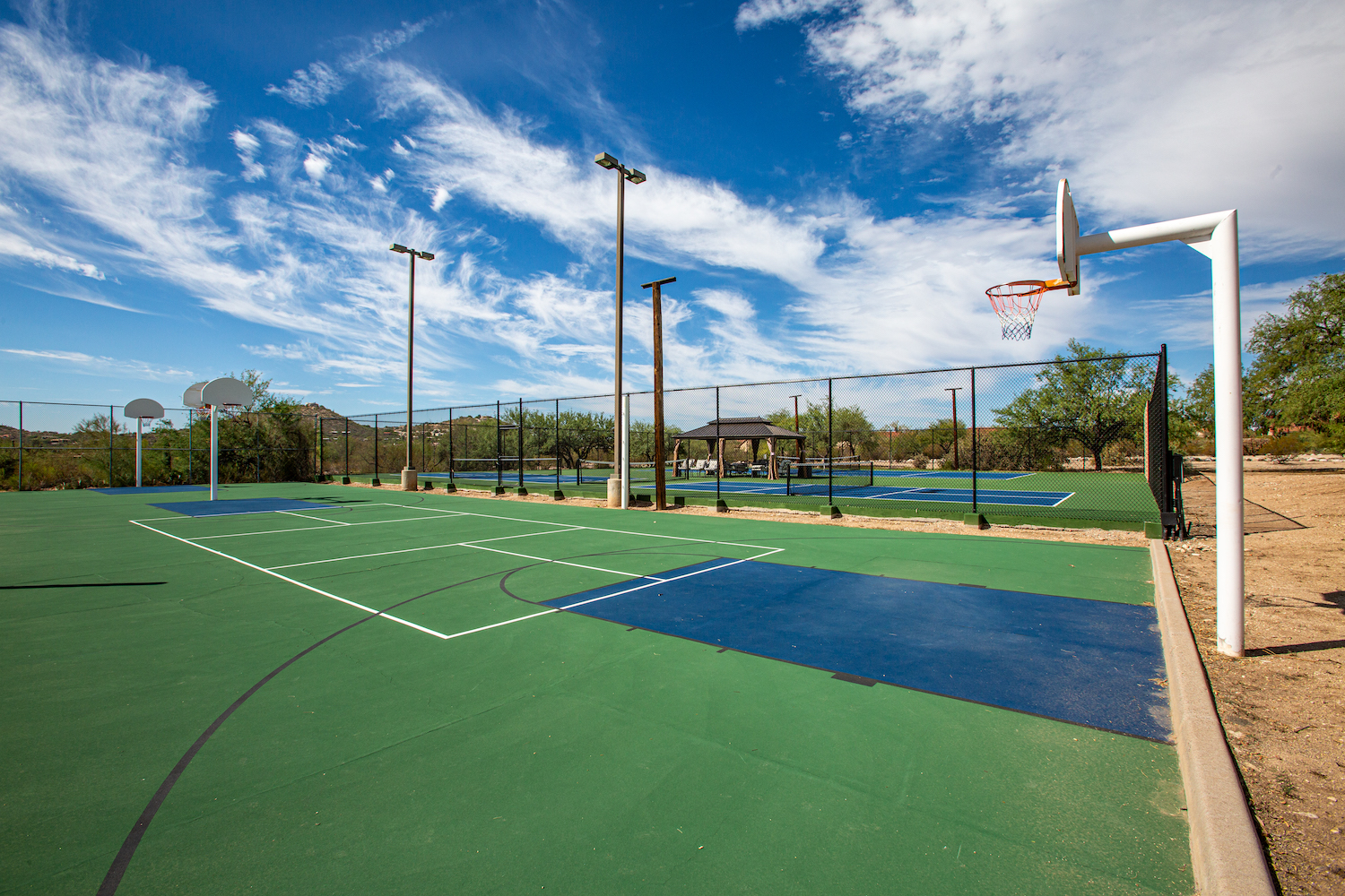 Outdoor basketball and tennis courts under a clear blue sky at Sabino Recovery