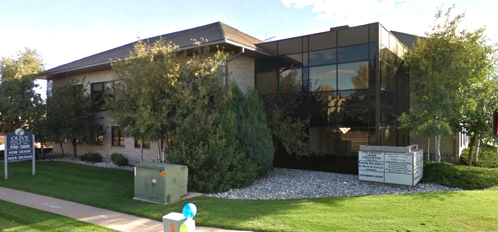 Two-story office building with mirrored glass and landscaping
