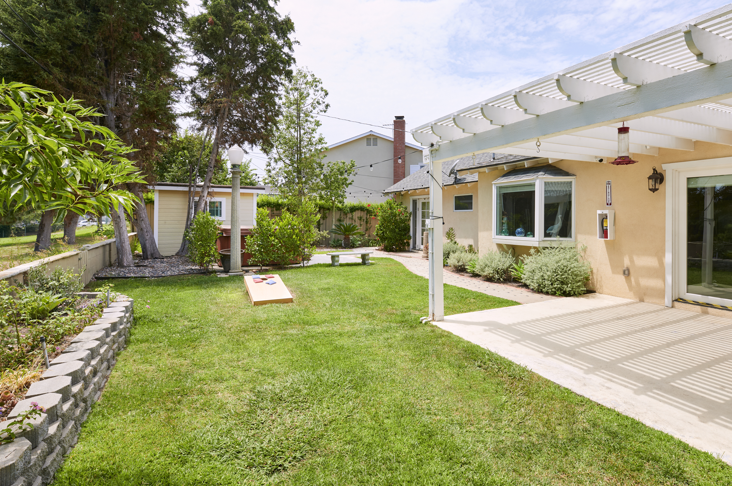 Backyard with a shaded pergola and seating.