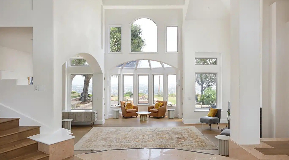 Spacious living room with tall windows and comfortable seating.