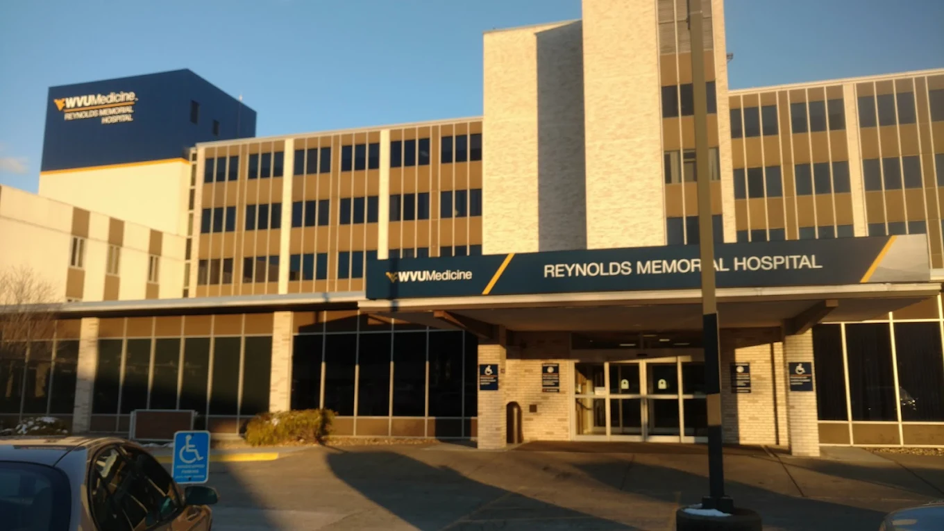 Exterior of WVU Reynolds Memorial with blue hospital signage